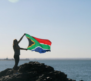 South African flag held by student on beach