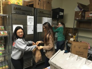 2 students volunteering in the food pantry