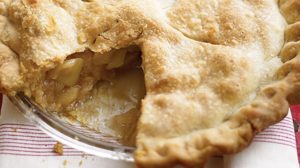 fresh apple pie with large piece cut out; crust is golden brown with fluted edge