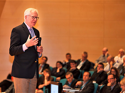 man holding microphone speaking to audience