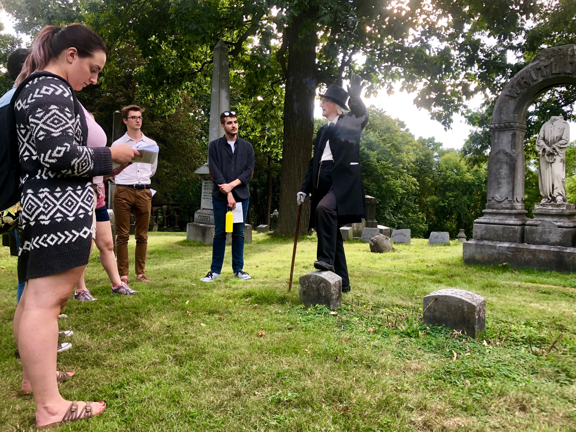 Students listening to speaker in cemetary