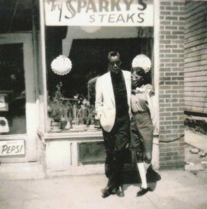 African American couple smartly dressed pose before a shop window