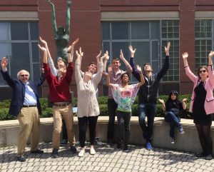 Class posing in front of a statue on campus